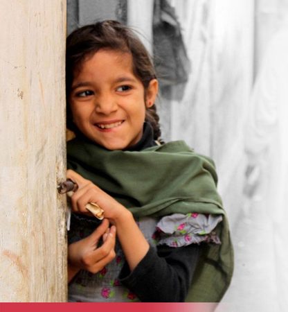A young girl at the doorway of her home in Karachi